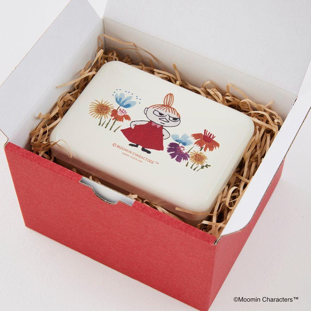 A red box containing a white container with a picture of a girl wearing a red dress and surrounded by flowers.