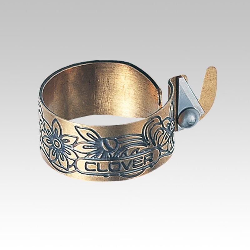 A decorative metal band with a floral pattern and the word "CLOVER" engraved on it.