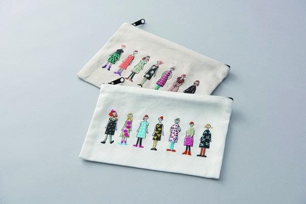 two white bags with colorful embroidered illustrations of women on them.