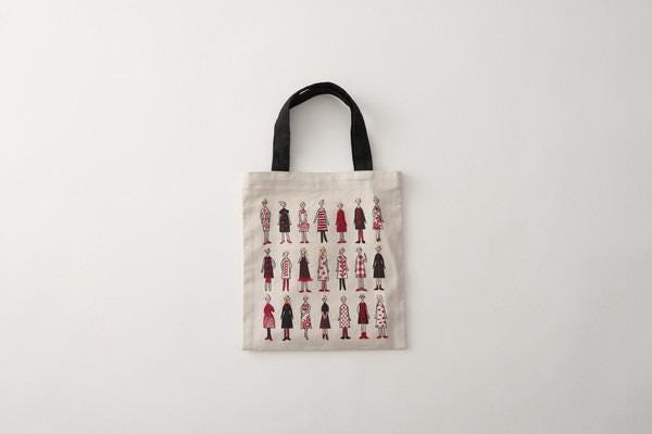 A beige tote bag with a black handle, featuring a repeating pattern of stylized human figures in various outfits.