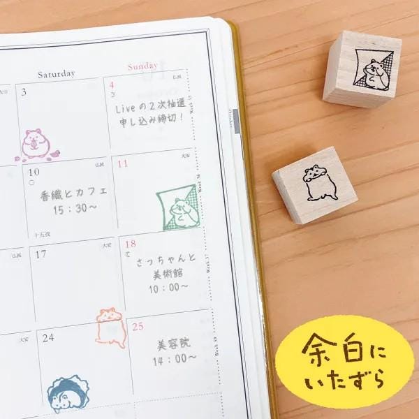 a calendar with a variety of animal-themed stickers and a set of wooden blocks with animal stickers, all placed on a wooden surface.