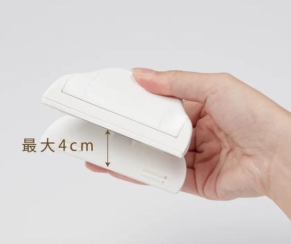 A hand holding a white object, which appears to be a small white device or tool.