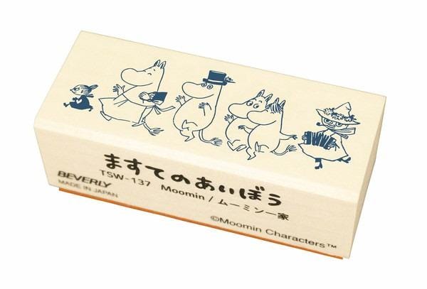 A wooden stamp featuring a group of cartoon characters, including Moomin characters, in various poses and outfits.