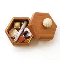 A wooden box with a hexagonal lid, containing various items such as a small white ball, a tube, and some other objects.