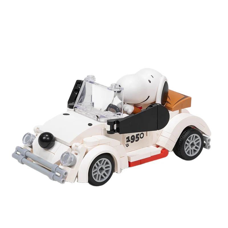 A toy car with a Snoopy character sitting in the driver's seat.