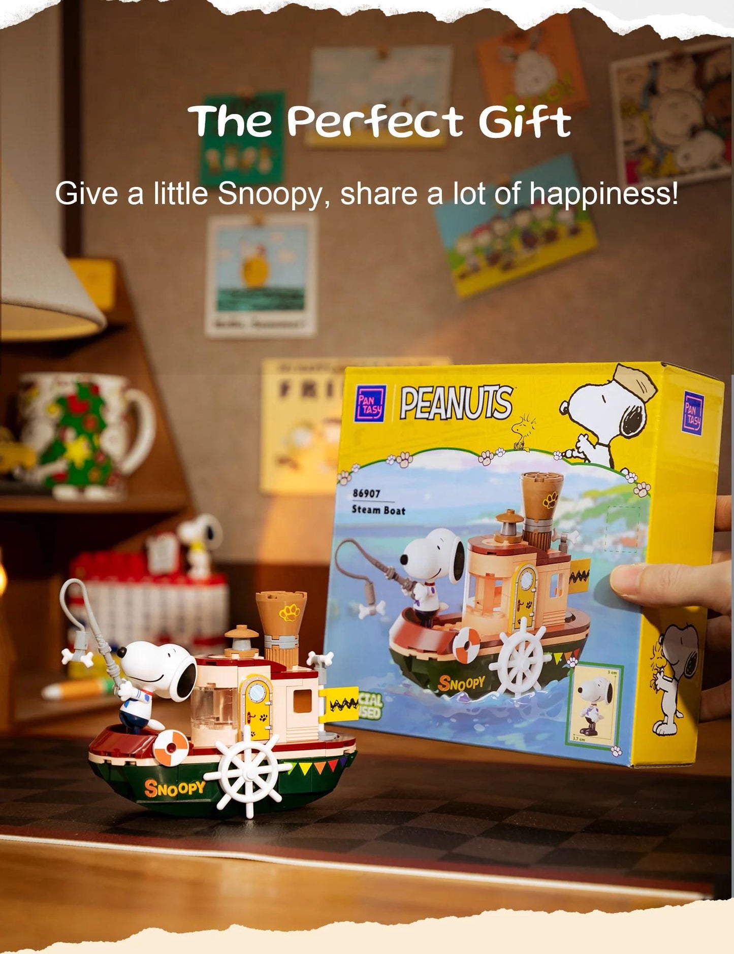 a hand holding a box of Peanuts-themed toy boats, with one boat in the foreground and another boat in the background.
