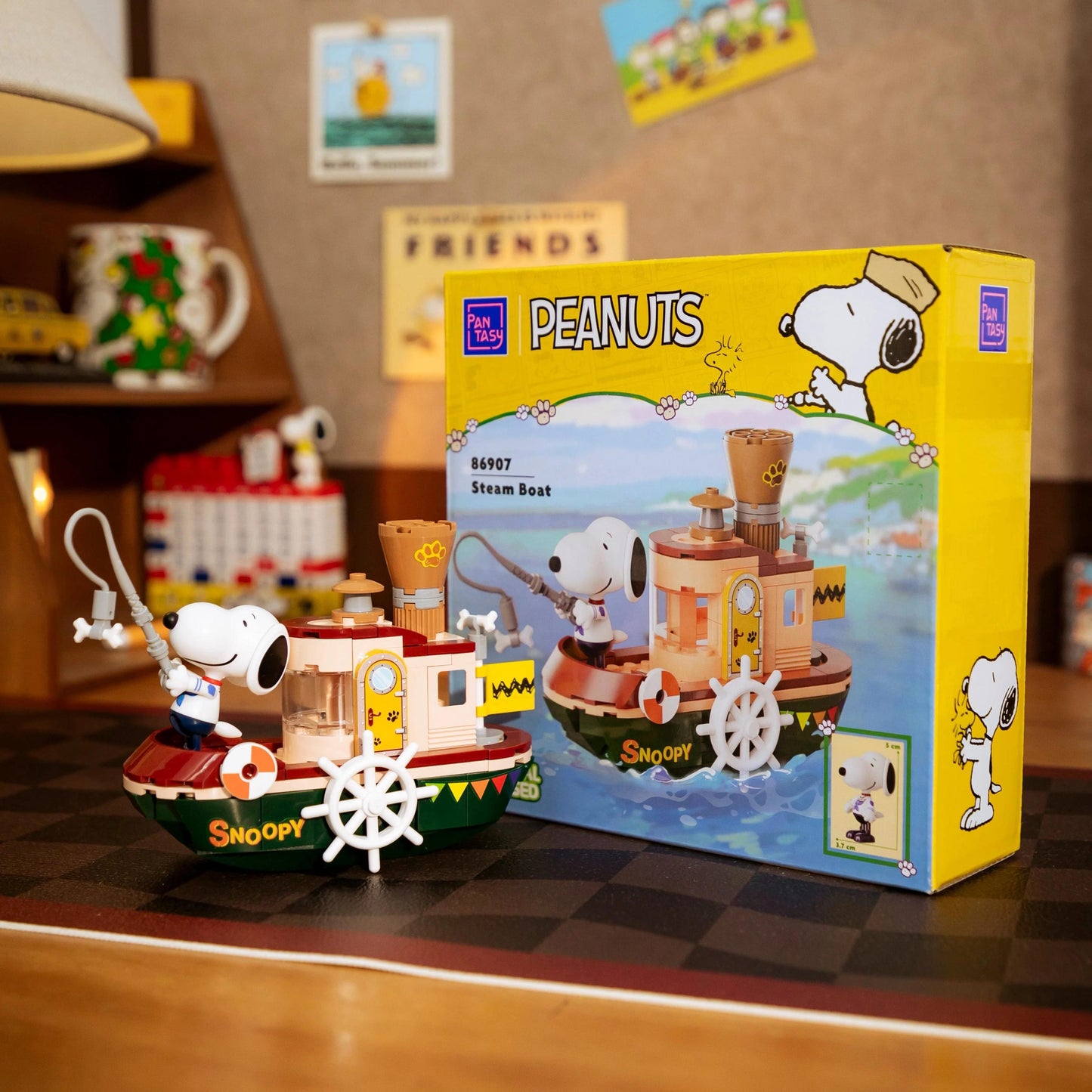 A Peanuts themed steamboat toy is displayed next to its packaging box, which features the character Snoopy.