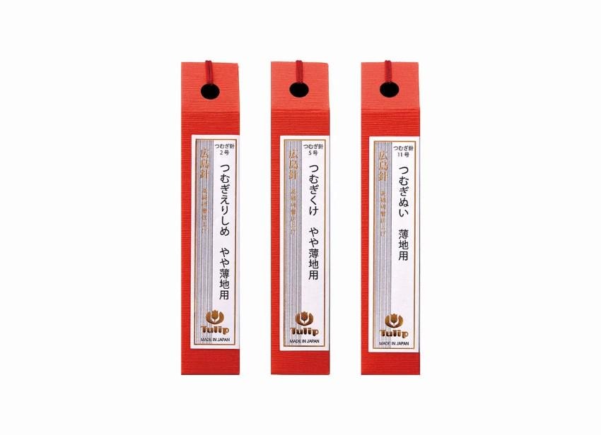 Three red pencil boxes with Japanese text and logos, each containing a pencil sharpener.