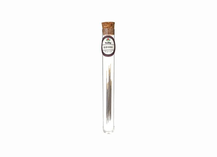 A clear glass tube with a cork stopper containing several small sticks or sticks of incense.