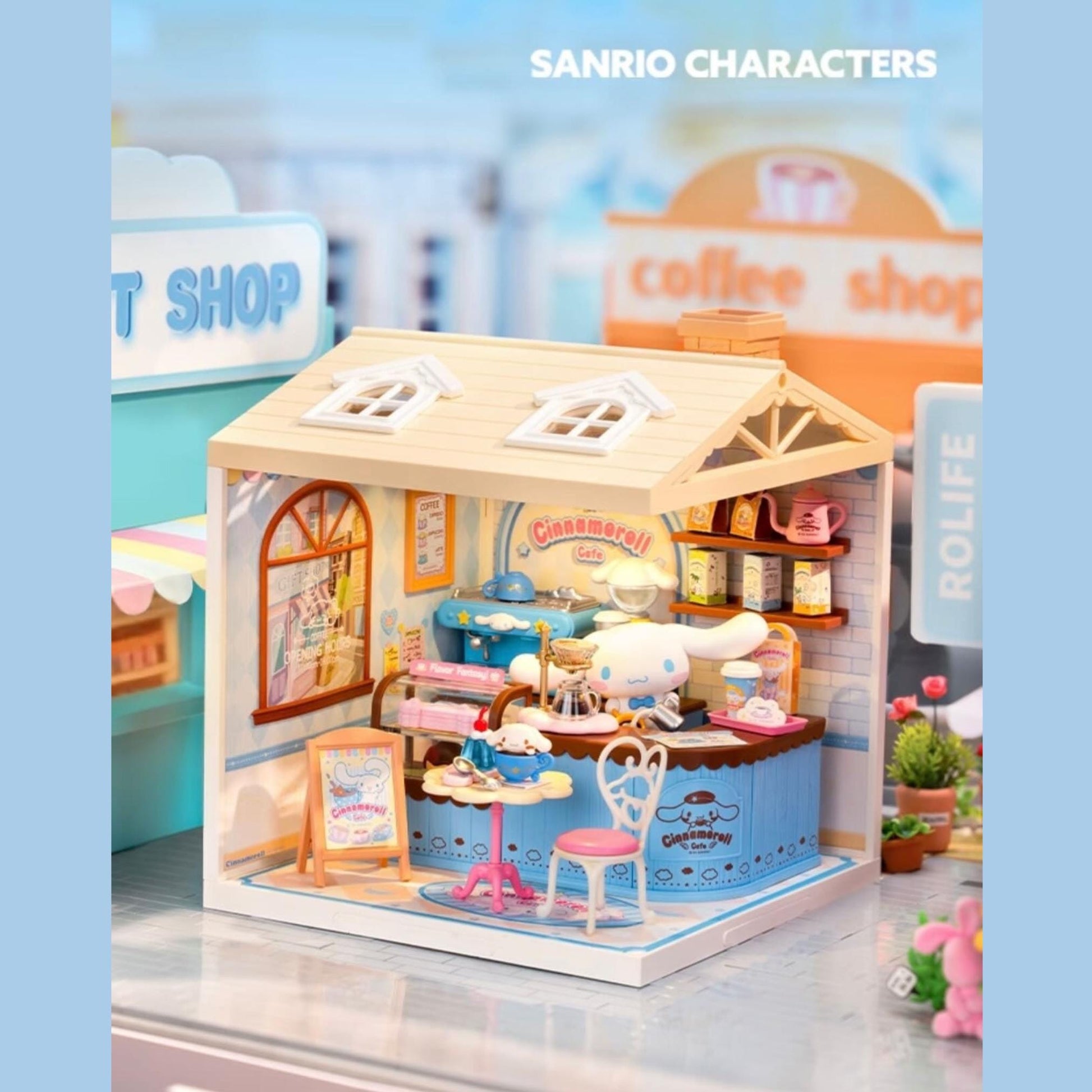 A miniature toy cafe with various elements such as a small table, chairs, a sign, and a small toy character inside the cafe.