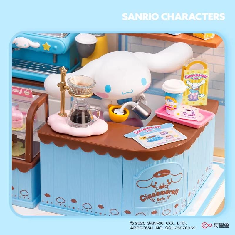 A toy cafe with a cute cartoon character, likely a character from the Sanrio brand, set up with various items such as a coffee machine, cups, and other accessories.