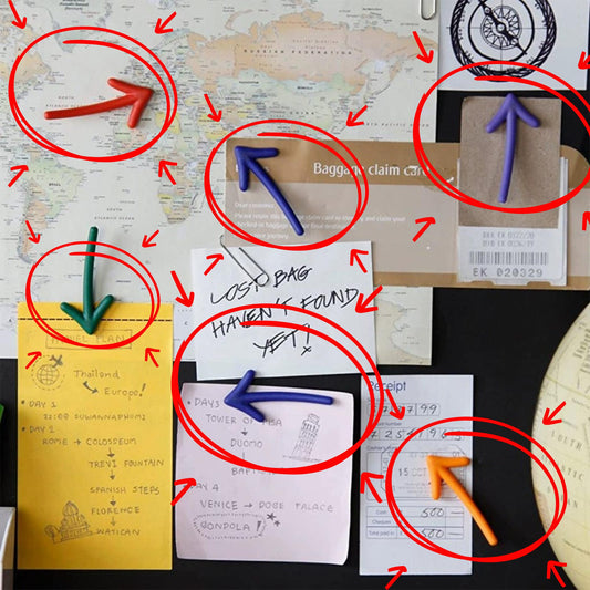 a bulletin board with various notes, papers, and arrows, suggesting a busy or organized workspace.