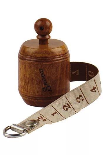 a wooden cylinder with a wooden top, and a beige measuring tape with numbers on it, both sitting on a white background.
