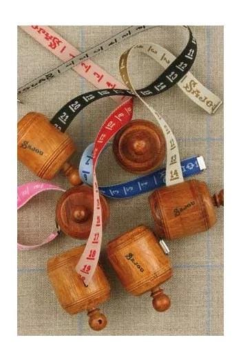a collection of wooden spools or measuring spools, each with a unique color and pattern, arranged on a textured surface.