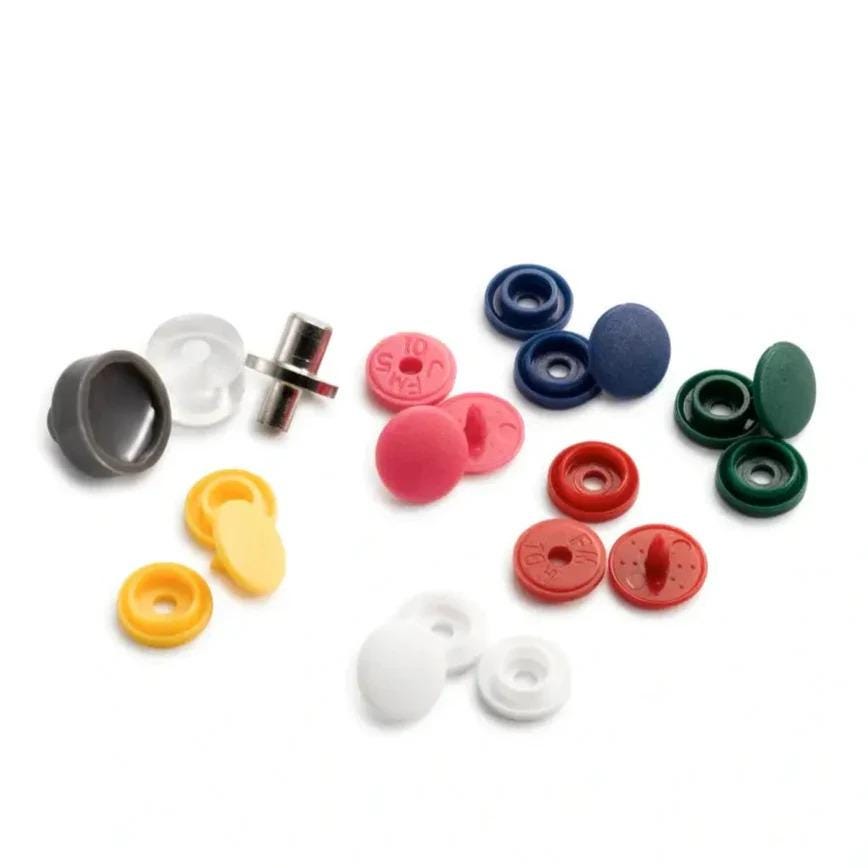 various colored plastic caps and fasteners, including black, yellow, red, blue, and green, arranged on a white background.