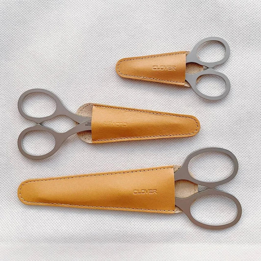 Three pairs of scissors with leather cases, each with the word "CLOVER" printed on them.