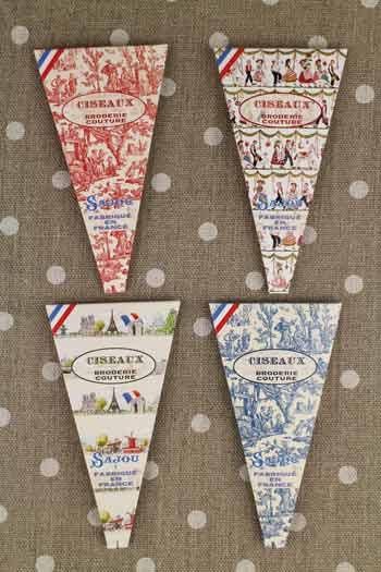 four triangular-shaped boxes with various designs and text, all featuring the word "CISEAUX" prominently displayed.