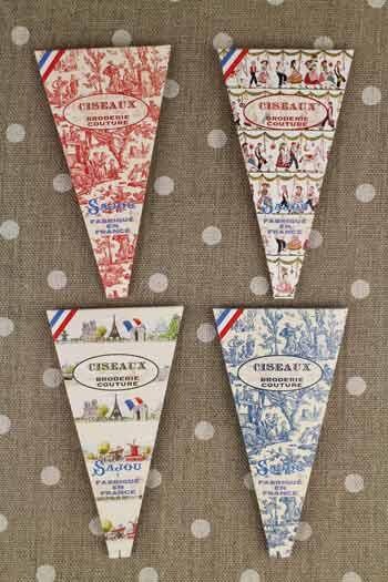 four triangular-shaped boxes with various designs and text, all featuring the word "CISEAUX" prominently displayed.