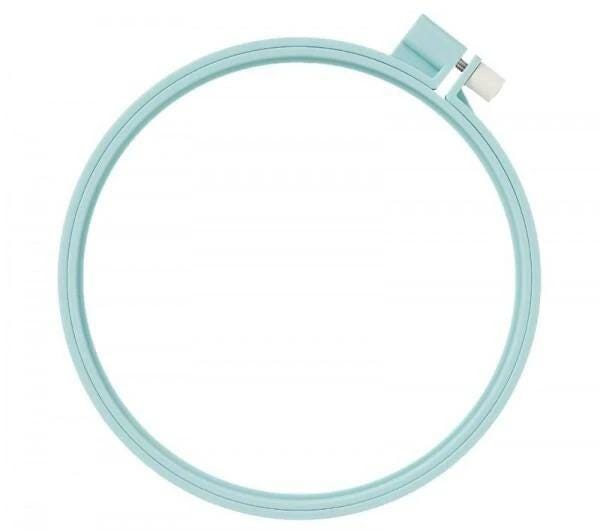 A turquoise-colored embroidery hoop with a white attachment on the top.