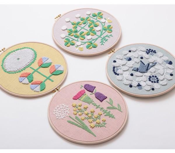 four circular embroidery hoops, each with a different floral design.
