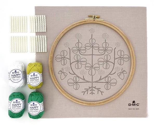 a kit for embroidery, including a hoop, yarn, and a pattern. The kit appears to be a kit for creating a floral design using embroidery.