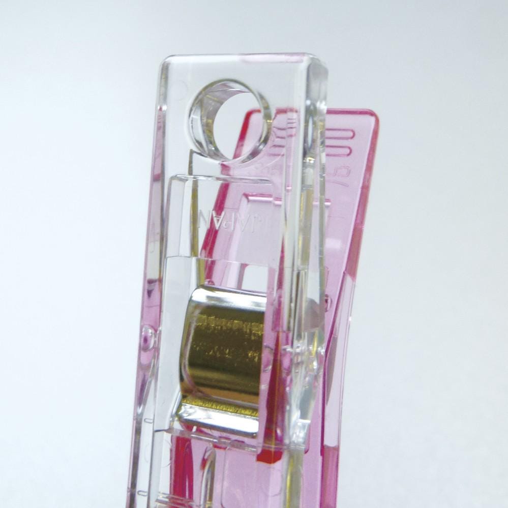 A clear plastic object with a metallic component, possibly a tool or accessory, is shown against a white background.