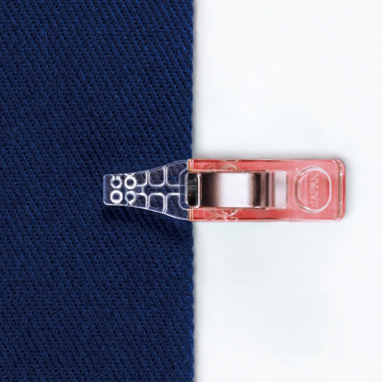 A clear plastic clip is attached to a piece of blue fabric, which is placed on a white background.
