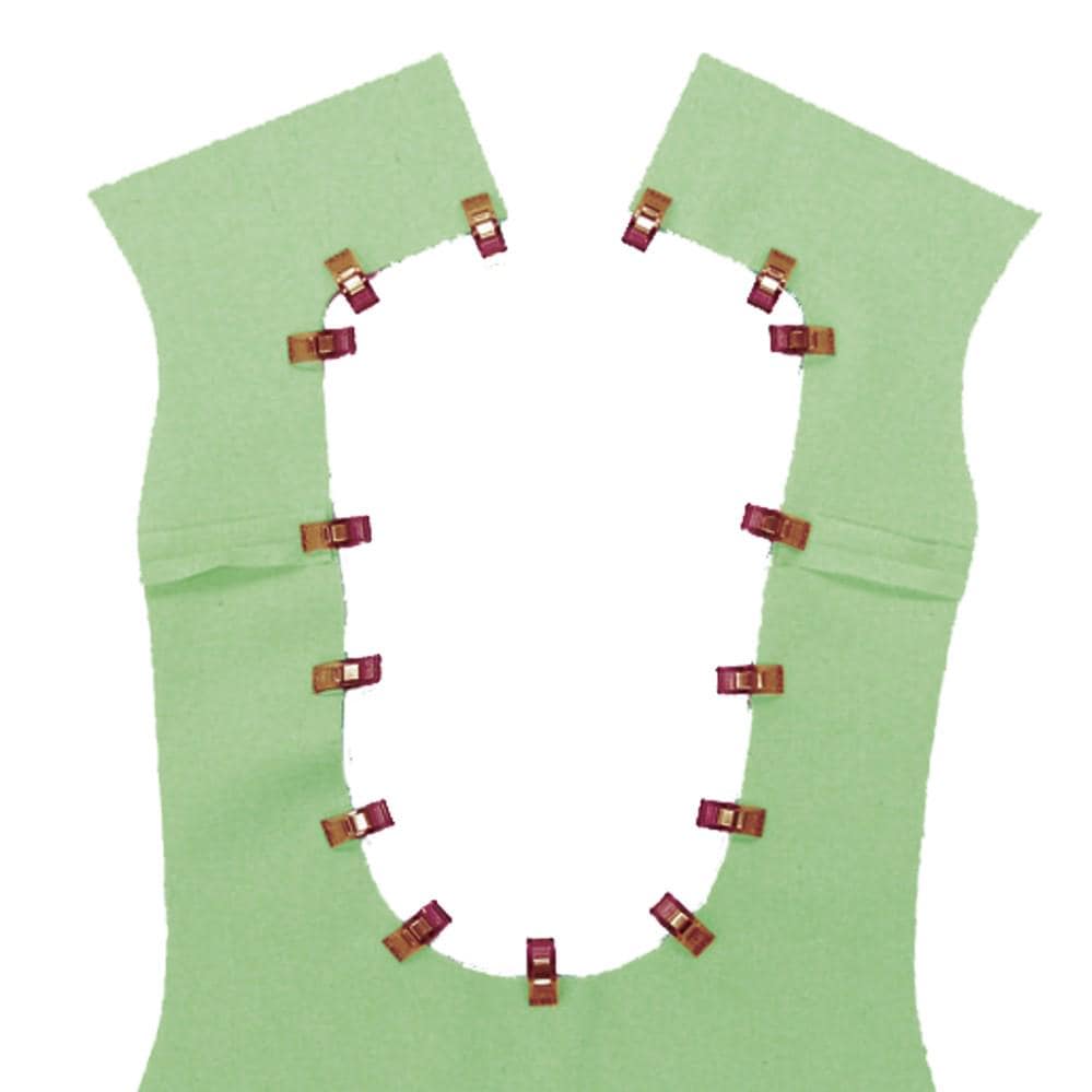 a green fabric with red clips attached to it, forming a circular pattern.