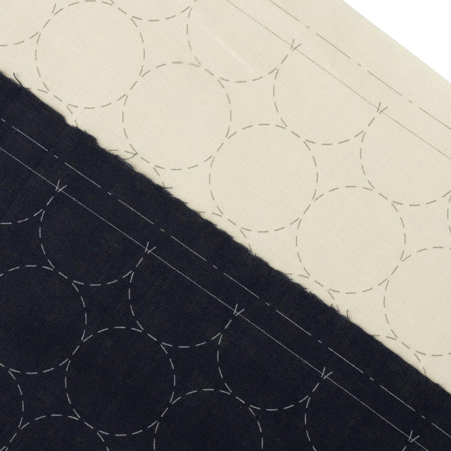a close-up view of a fabric with a repeating pattern of circles, with some areas appearing darker than others.