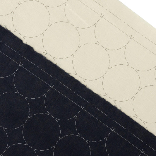 a close-up view of a fabric with a repeating pattern of circles, with some areas appearing darker than others.