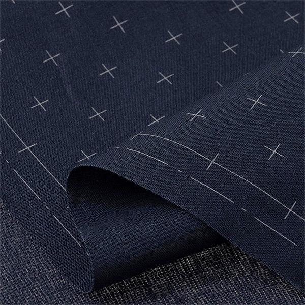a close-up view of a dark blue fabric with white crosses or lines, creating a patterned design.