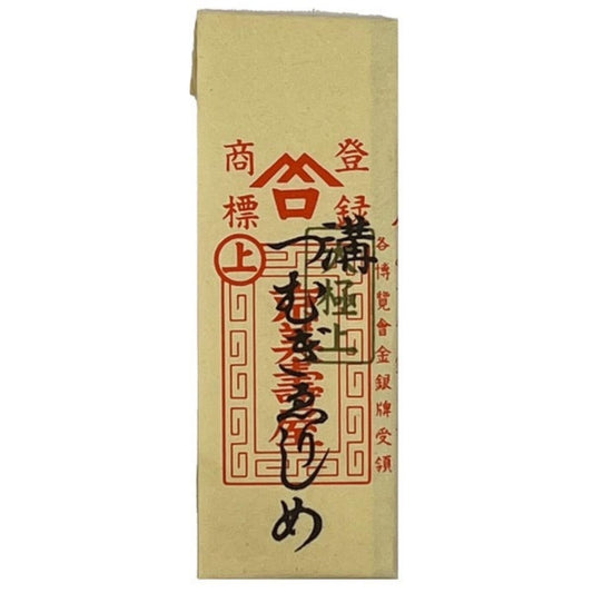 a beige paper with red and black text and symbols, including Chinese characters. The paper appears to be a printed item, possibly a label or a document, with a lot of text and symbols on it.