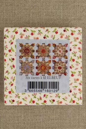 The image is a square-shaped box with a floral pattern on the border. The box has a barcode and text on it.