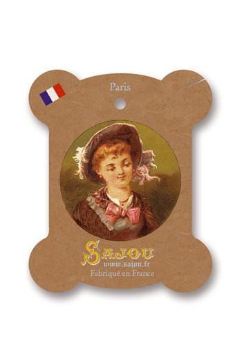 a woman wearing a hat and a pink bow, with a French flag sticker on the top left corner.