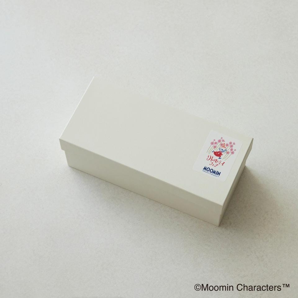 A white box with a sticker on it, placed on a plain white surface.