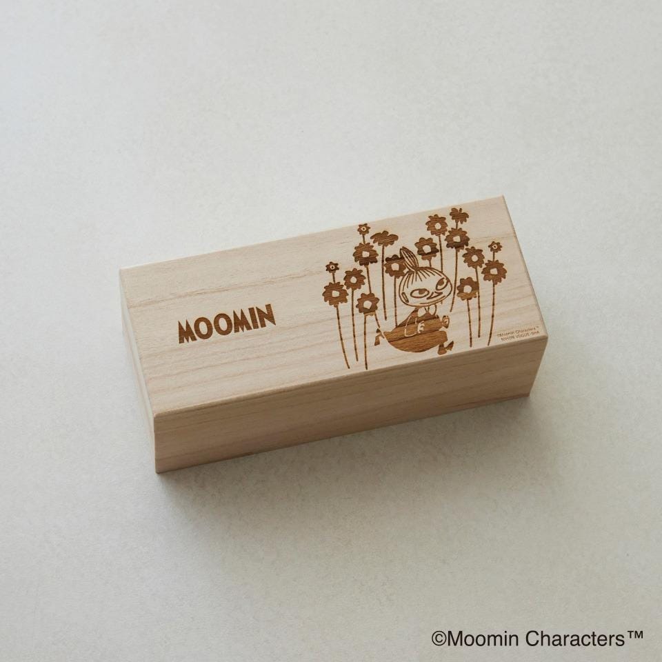 A wooden box with a floral design and the word "Moomin" printed on it.