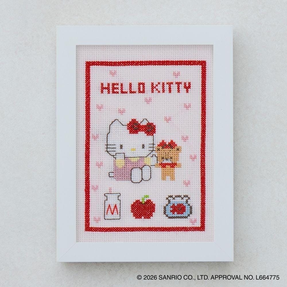 The image is a framed cross-stitch depicting the characters Hello Kitty and her dog.
