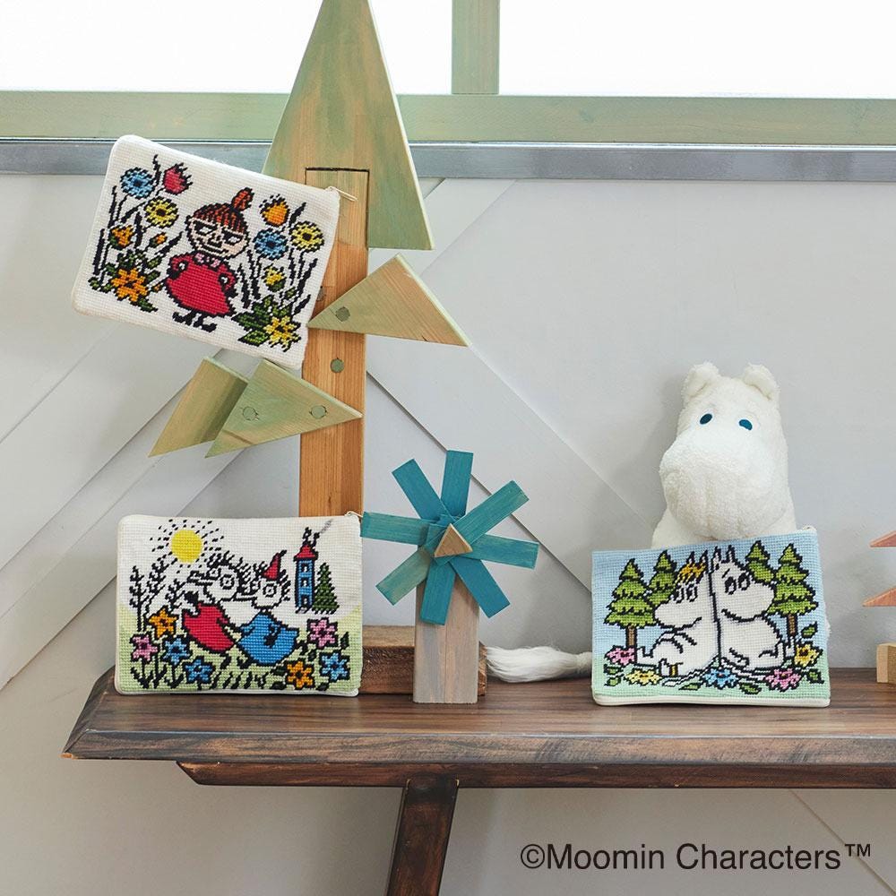 a wooden shelf with various knitted and crocheted items, including a windmill, a stuffed animal, and a small picture frame.