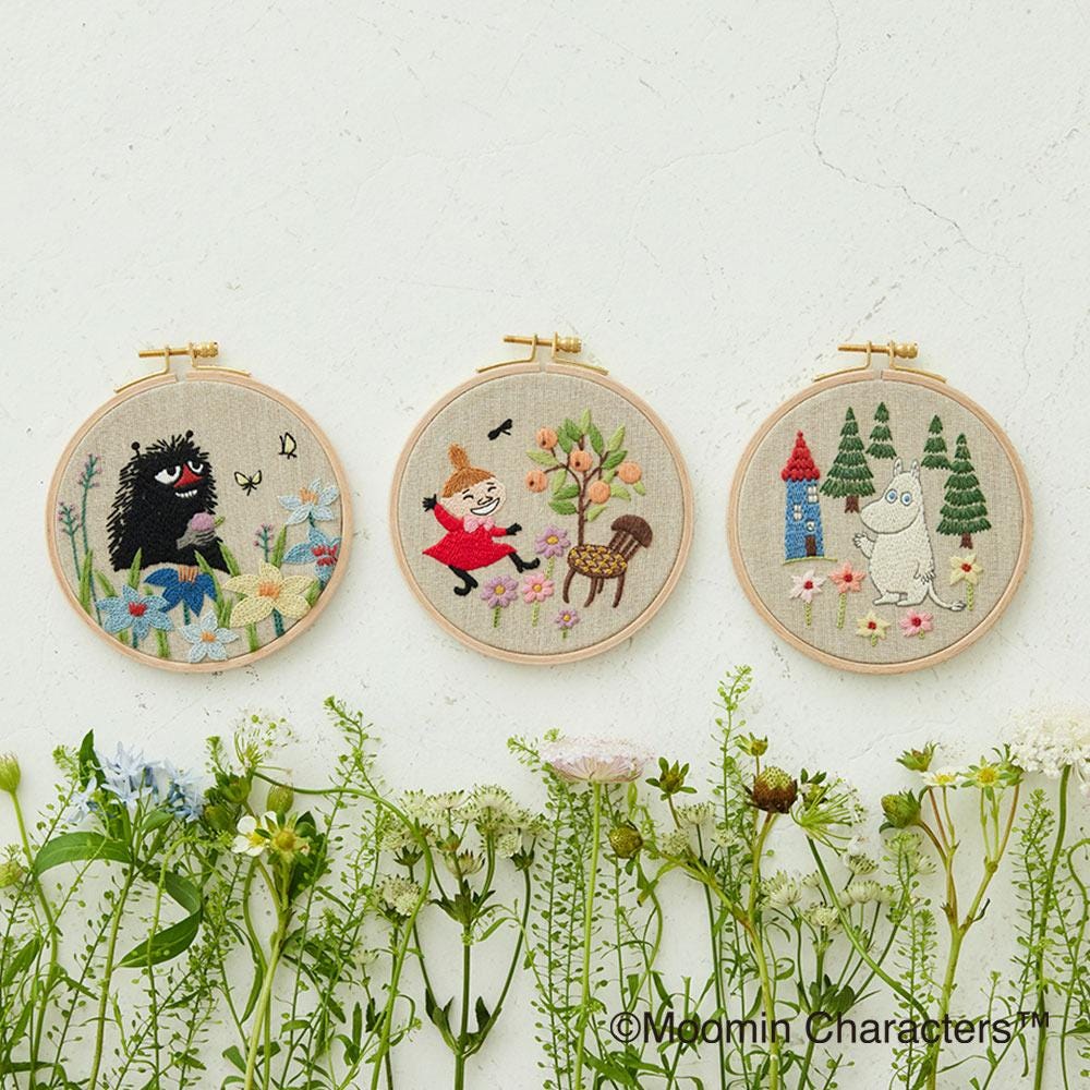 three embroidered scenes depicting characters from the Moomin series, arranged in a row on a white background.