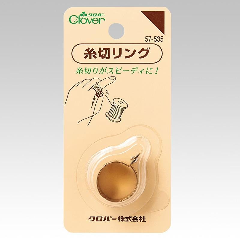 a product packaging for a product with a hand holding a spool of thread.