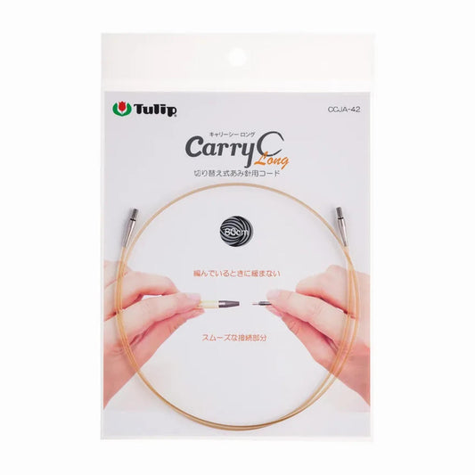 a package for a knitting needle, specifically a "Carry Long" knitting needle. The package features a close-up of a hand holding the needle, along with the product name and a circular logo.