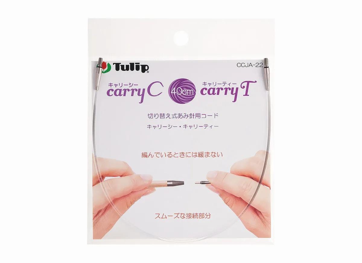 a package for a knitting or crochet project, featuring a pair of hands holding a clear plastic knitting needle.