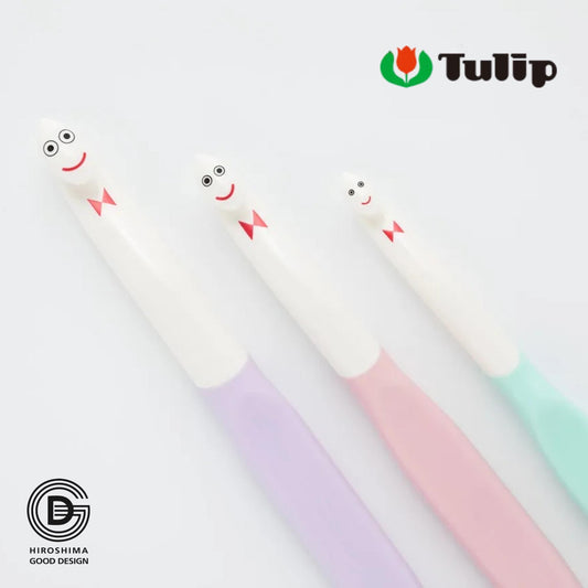 three toothbrushes with colorful handles and small faces on them, arranged in a row.