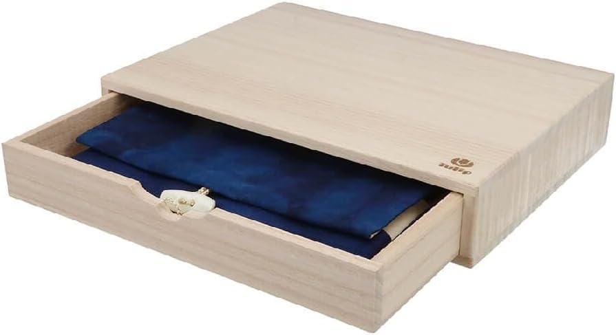 A wooden drawer with a blue fabric item inside, and a small white object on the front of the drawer.