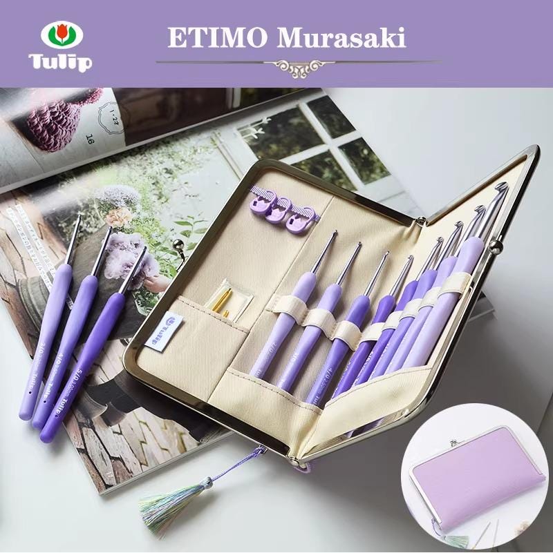A set of purple crochet hooks and needles in a case, along with a magazine featuring a crochet pattern.