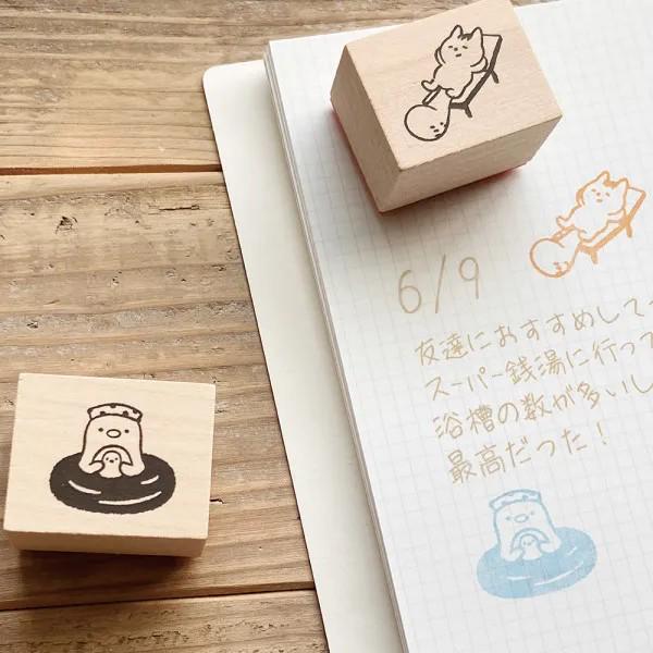 a wooden stamp with a cartoon character and a piece of paper with Japanese text and a grid pattern.