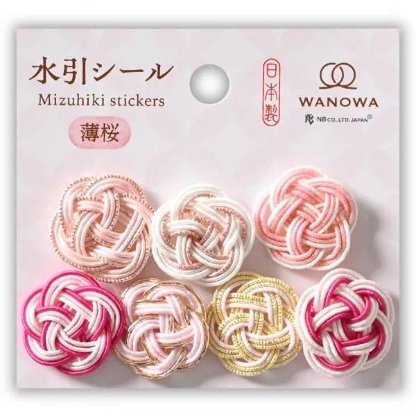 a collection of six colorful, knotted or braided objects arranged in a grid pattern. The objects appear to be decorative items, possibly intended for use as hair accessories or decorations.