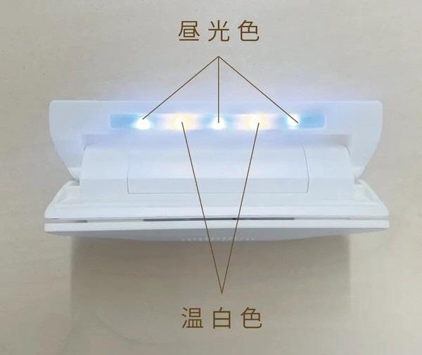 a white electronic device with a triangular shape and a row of lights on the top.
