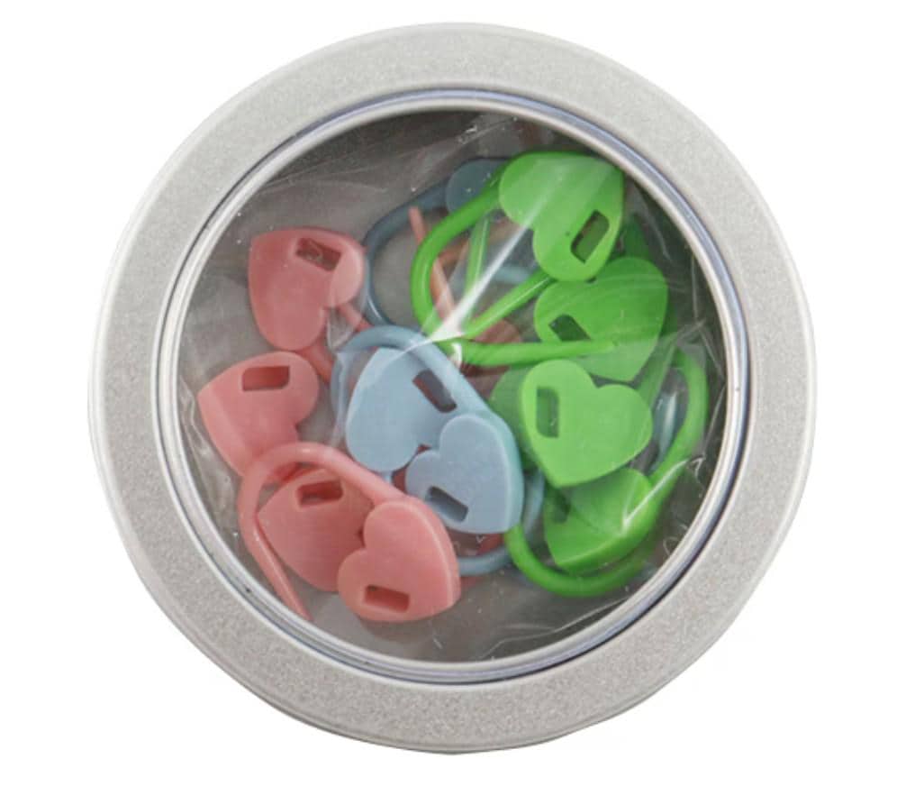 A silver tin can containing a collection of colorful plastic heart-shaped objects, including pink, blue, and green hearts.