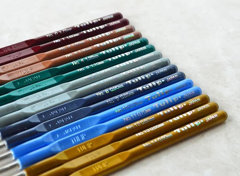 A collection of colorful crochet hooks arranged in a row, with each hook having a different color and size.